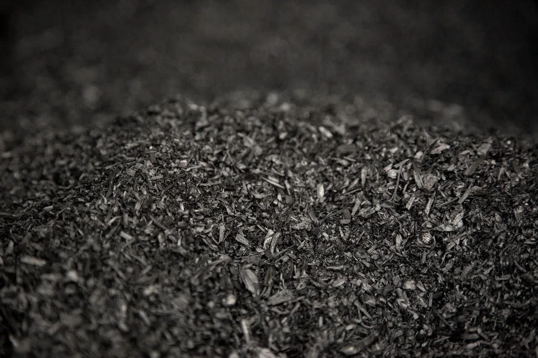 Finished biochar — black, granular charcoal ready to be charged and buried.